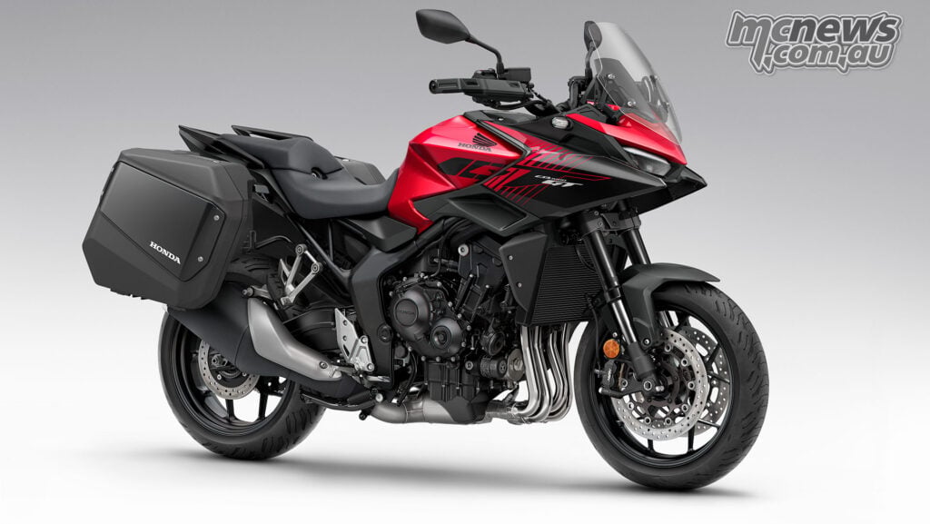 Studio front three-quarter view of the red 2026 Honda CB1000GT fitted with black hard panniers.