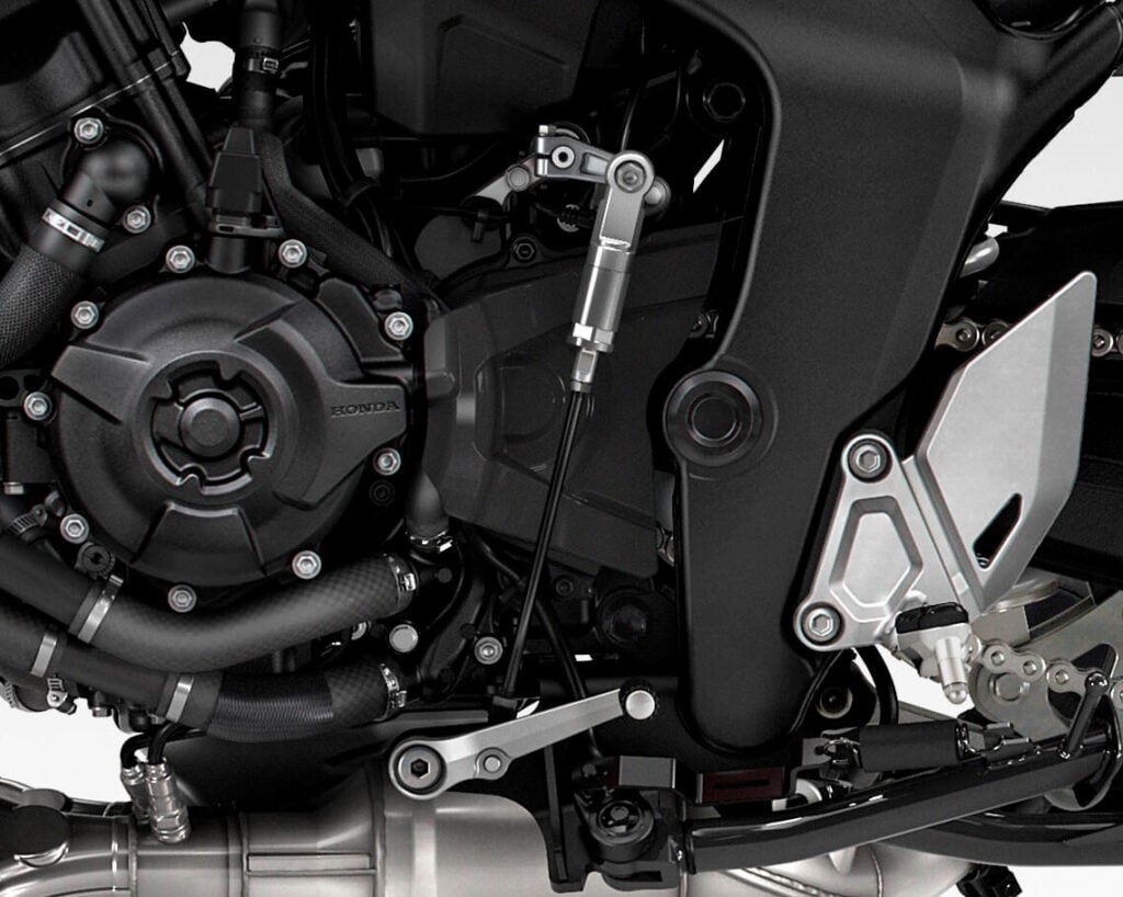 Close-up of the 2026 Honda CB1000GT engine, gear linkage and standard two-way quick-shifter sensor.