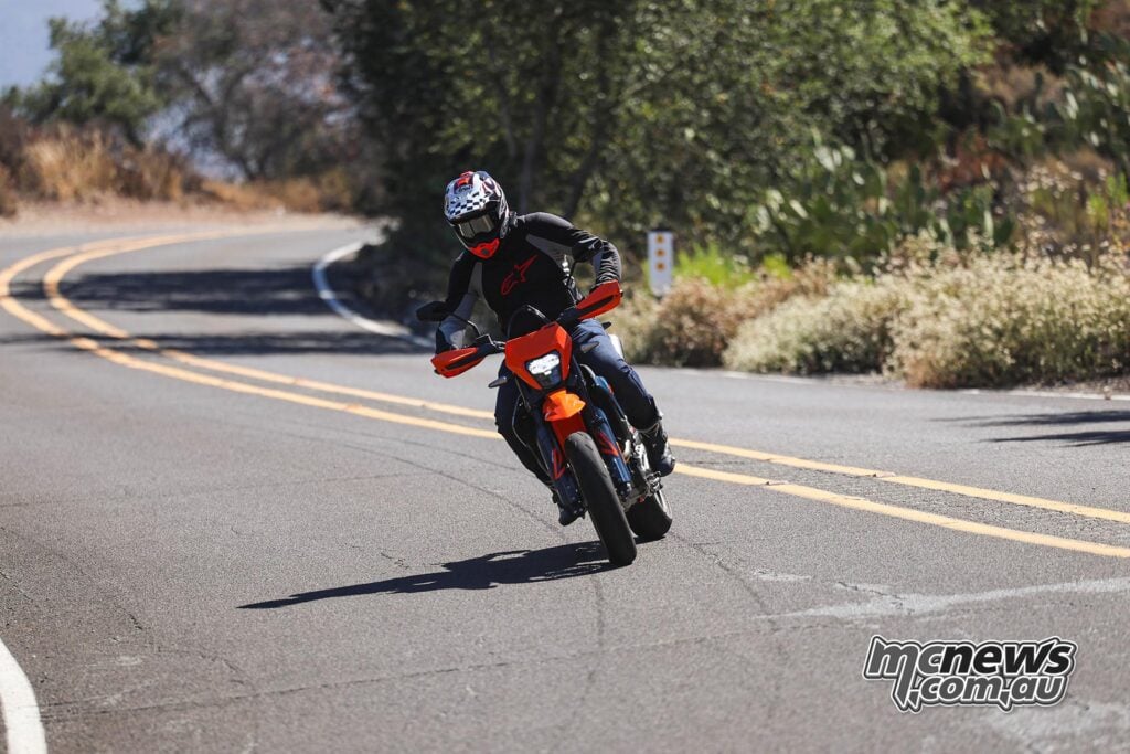 2026 KTM 690 SMC R ridden through a sweeping bend on a narrow back road.
