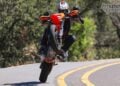 2026 KTM 690 SMC R lifting the front wheel on a winding road during road test.