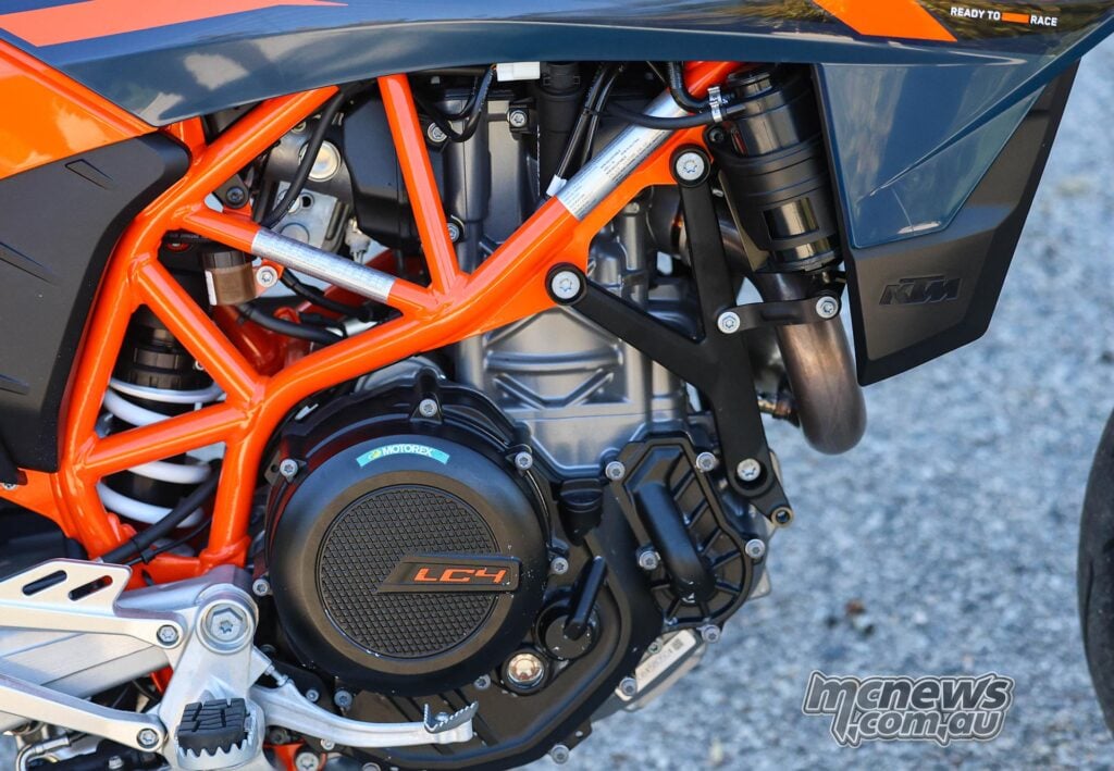 Close-up of the 2026 KTM 690 SMC R LC4 single-cylinder engine and orange trellis frame.