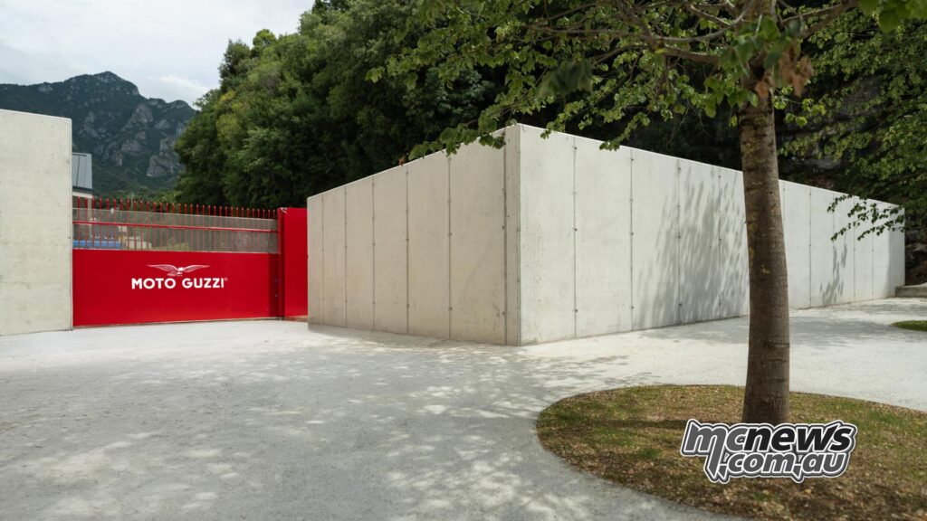 Red Moto Guzzi entrance between modern concrete walls in Mandello del Lario.