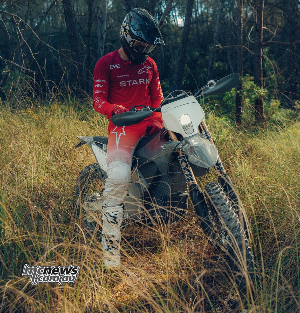 Rider seated on a Forest Gray Stark VARG EX Factory Edition in a wooded meadow.