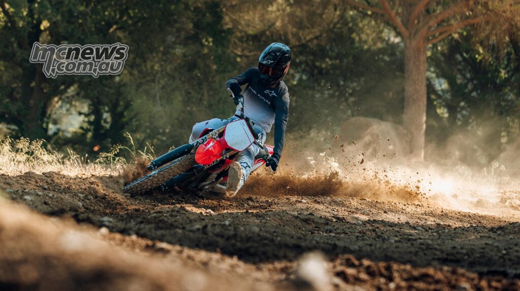 The rider is sliding the Stark Class MX Factory Edition through a loose dirt corner.
