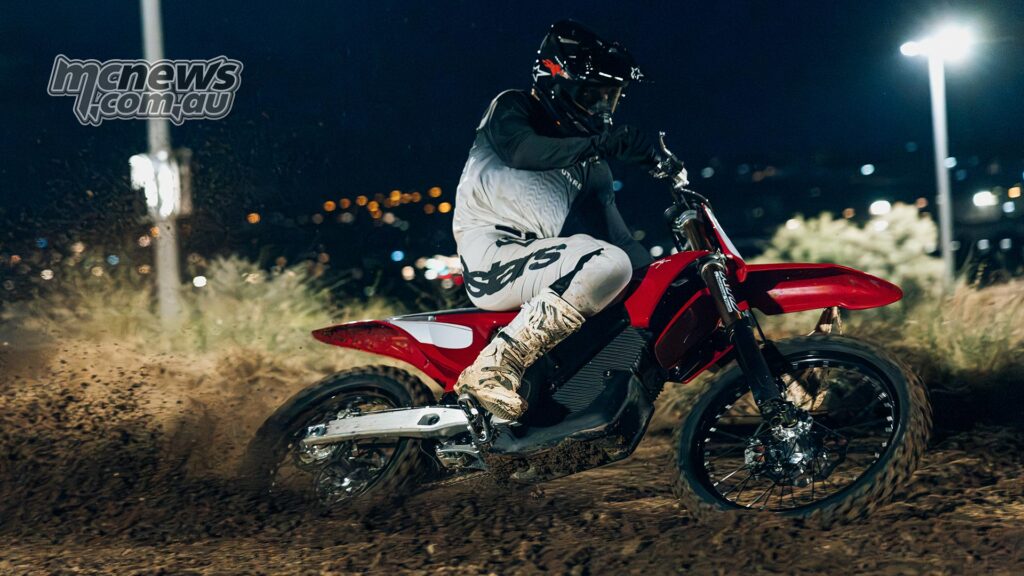 The rider is cornering the red stark VARG MX Factory Edition under floodlights at night.