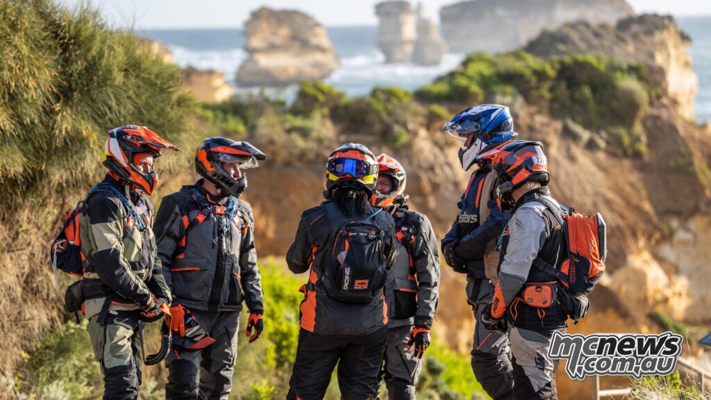 A group of KTM Adventure Rally riders gathered near limestone formations on Victoria's coast.