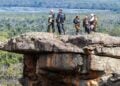 KTM Adventure Rallye riders standing on a rocky lookout above the Grampians landscape.