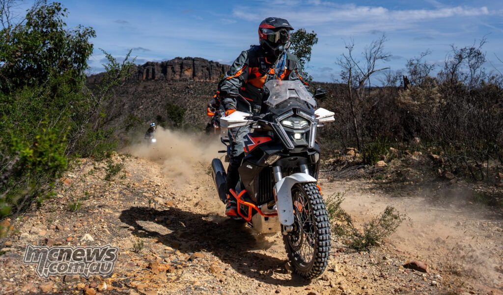A KTM adventure motorcyclist tackles rocky and dusty off-road terrain in Victoria.