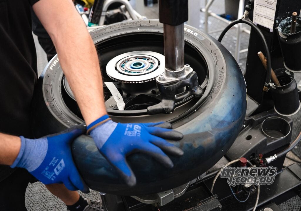 Technician works on a prototype Pirelli MotoGP slick tyre during 2027 tyre development testing at Brno.