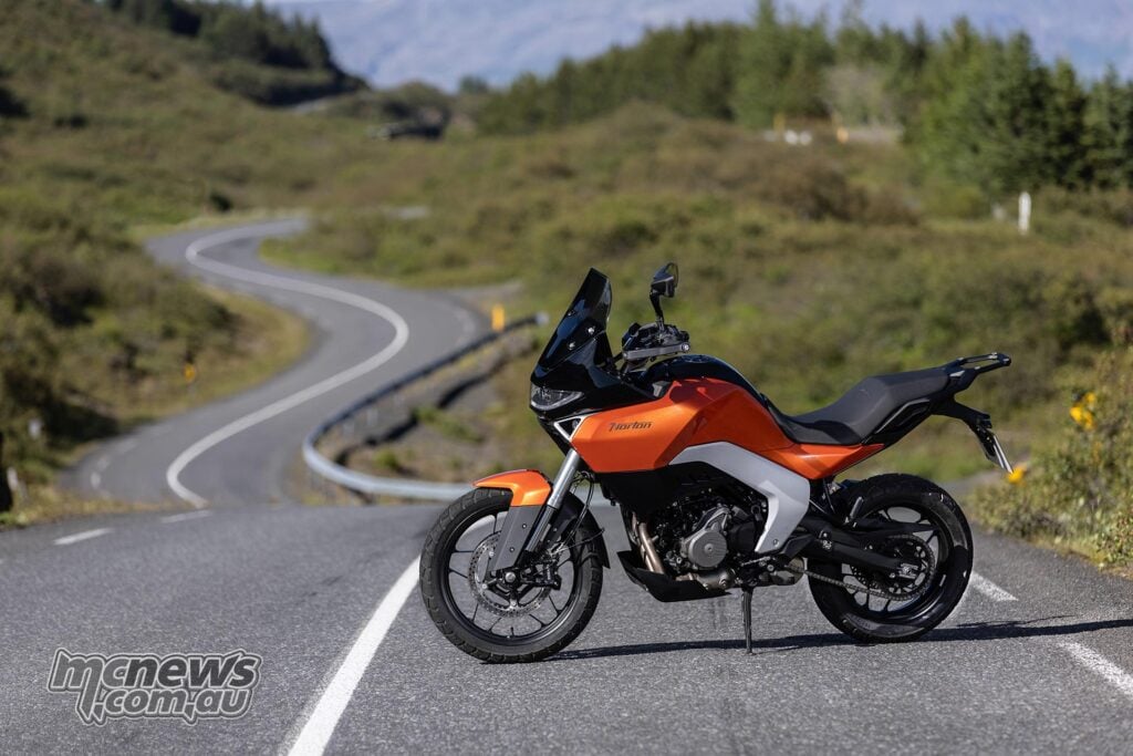 Orange Norton Atlas parked side-on on a winding Icelandic road.