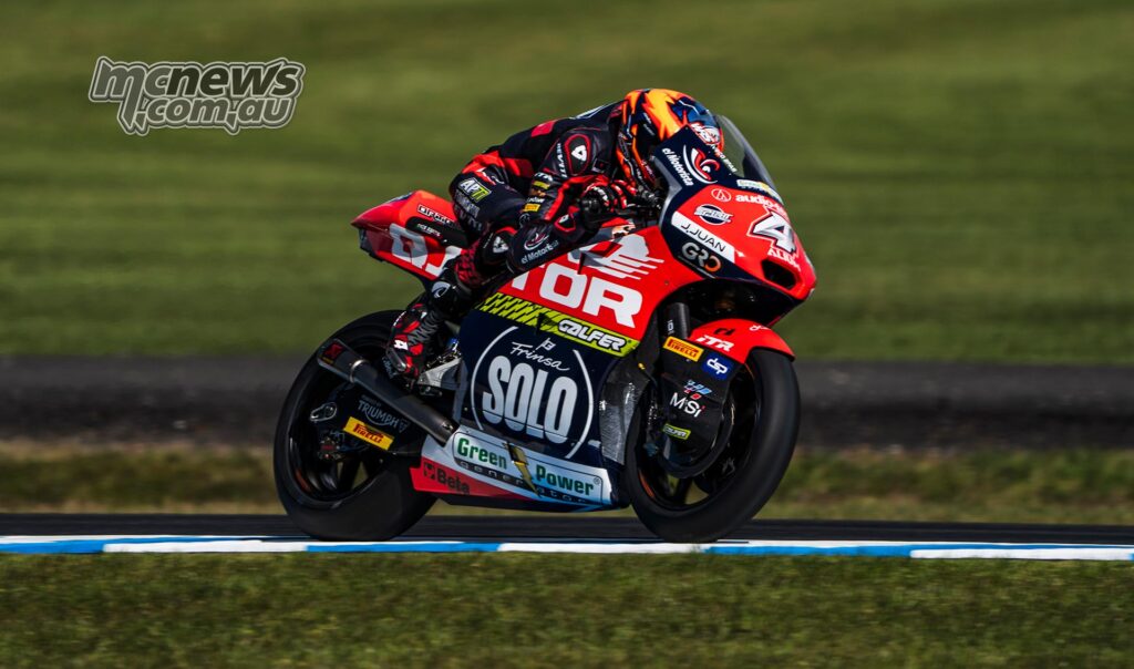 A Moto2 race bike sponsored by QJMOTOR leans over a corner on the track.