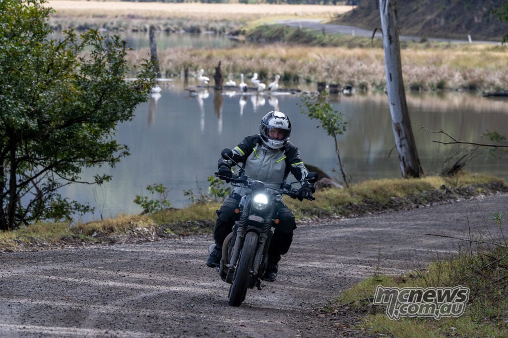 Trev riding a black BSA Scrambler 650 on a dirt road