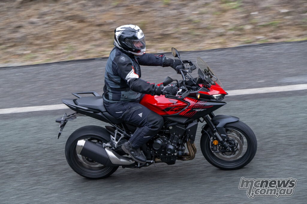 Rider on a red Honda CB1000GT in an elevated right-side action view.