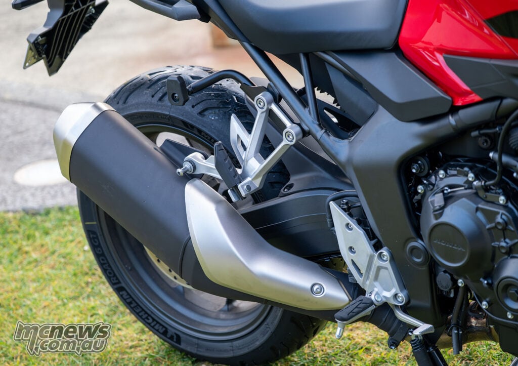 Close-up of the Honda CB1000GT exhaust silencer, footpegs, rear wheel and subframe.