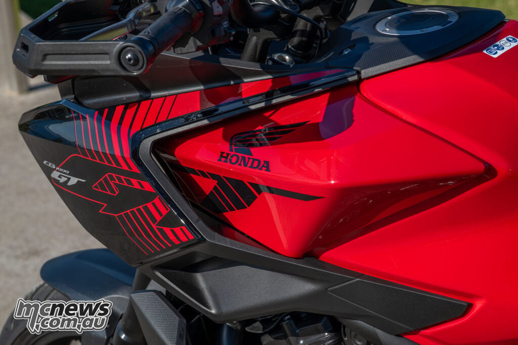 Close-up of the Honda CB1000GT fuel tank, Honda badge and red-and-black fairing graphics.