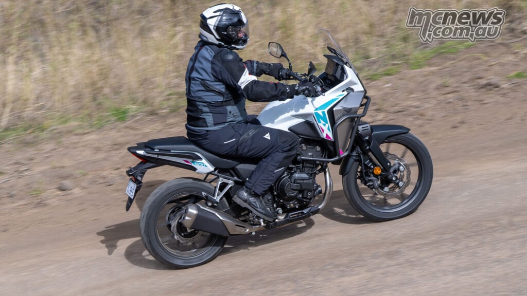 Rear-side view of Trevor Hedge riding a white Honda NX500 on the road