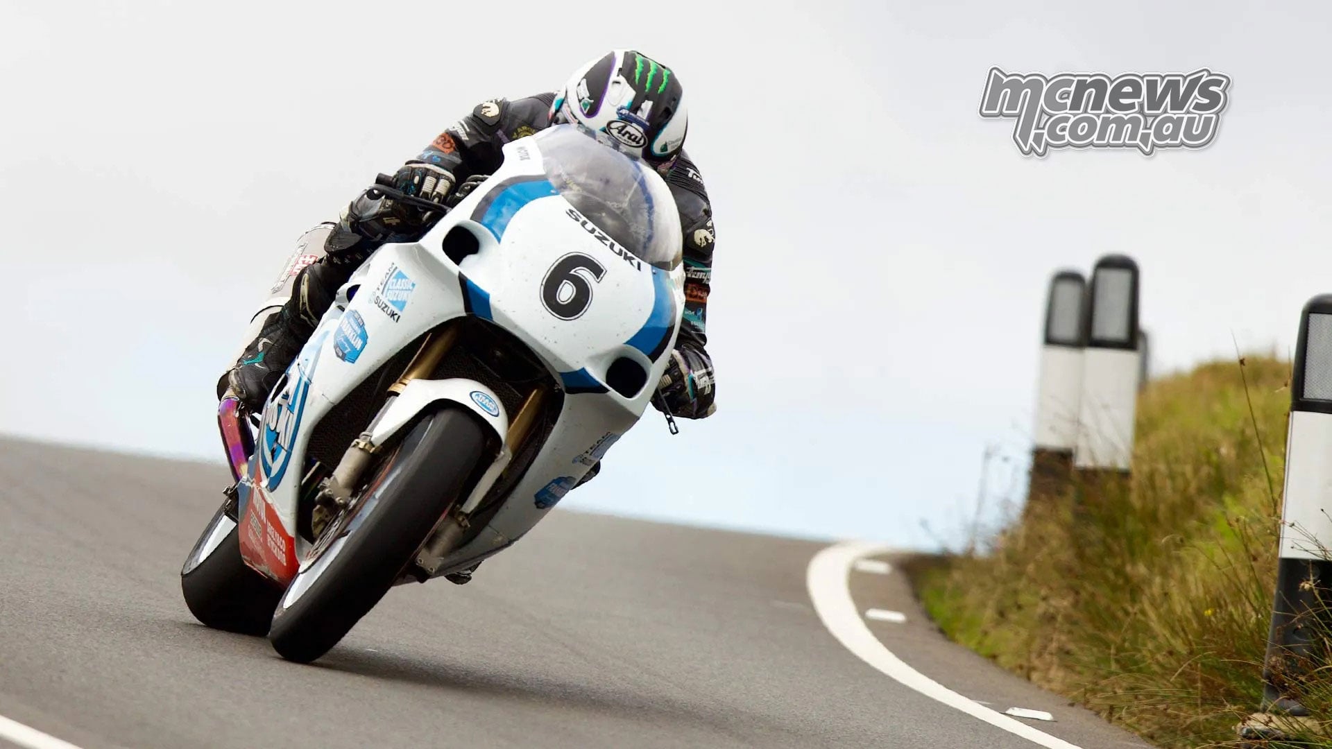 Michael Dunlop crests a rise aboard his white and blue number six Suzuki