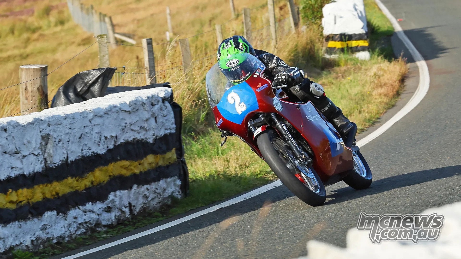 Mike Browne corners on his red number two historic racing motorcycle