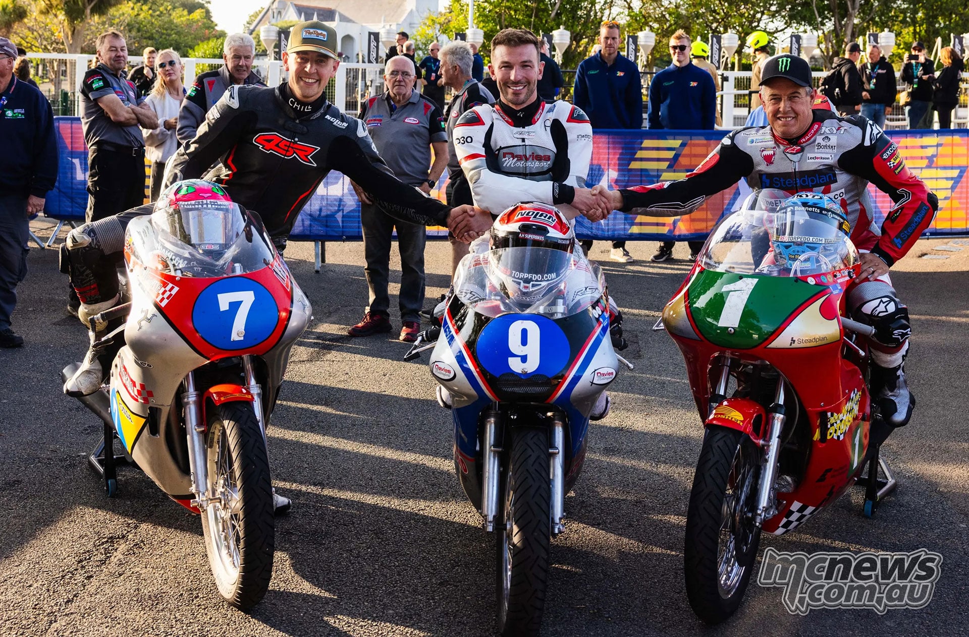 The Historic Junior podium finishers pose on their motorcycles in parc ferme