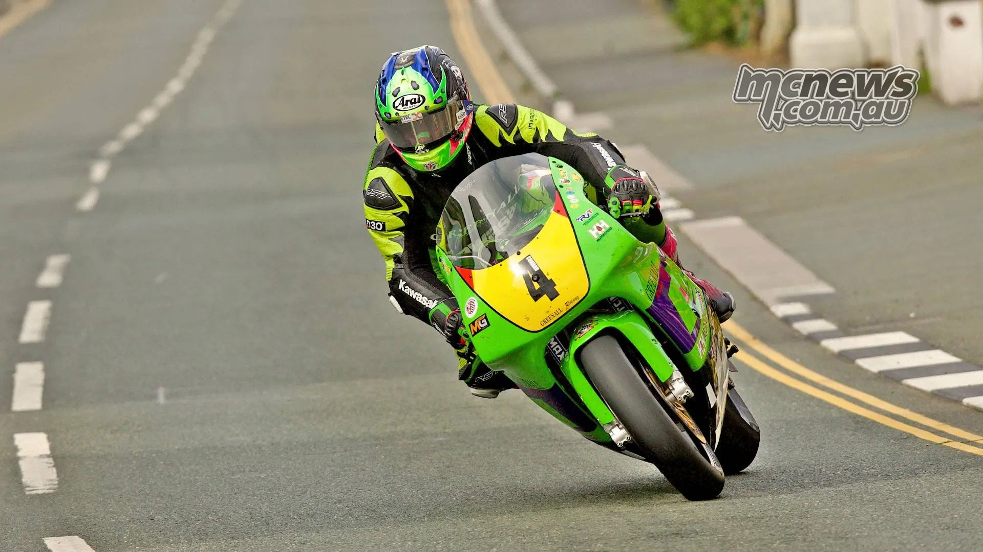 Jamie Coward rides his green number four Kawasaki along a narrow road