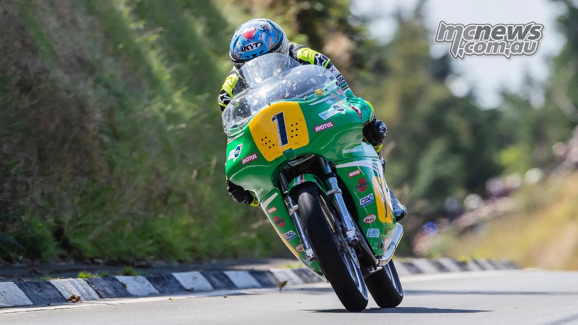 John McGuinness lifts the front wheel of his green number one Paton