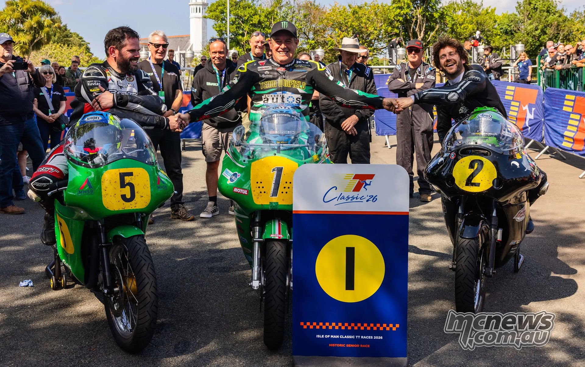 Shaun Anderson, John McGuinness and Mike Browne pose on their historic racing motorcycles