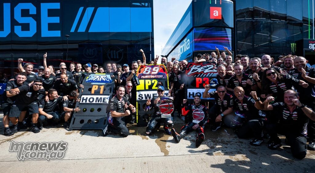 Aprilia and Trackhouse teams celebrate the all-Aprilia podium after the 2026 British MotoGP at Silverstone.