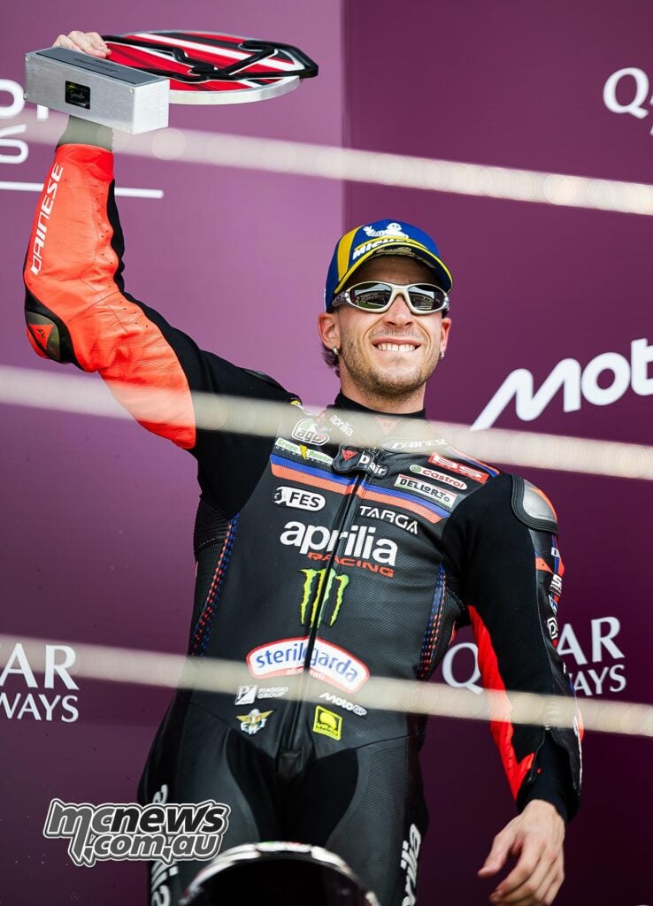 Marco Bezzecchi holds his third-place trophy on the British MotoGP podium at Silverstone.