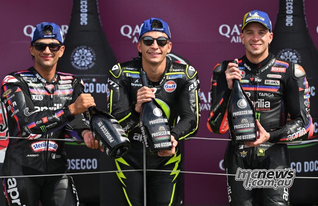 Raúl Fernández stands between Jorge Martín and Marco Bezzecchi after Aprilia swept all three British MotoGP podium positions.
