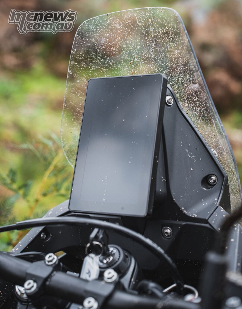 Close-up of the seven-inch vertical TFT and windscreen on a muddy Rieju Aventura Rally 307