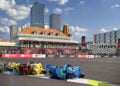 MotoGP riders leaning through the flowing Stag Corner with the Stag Hotel and Adelaide buildings behind them.