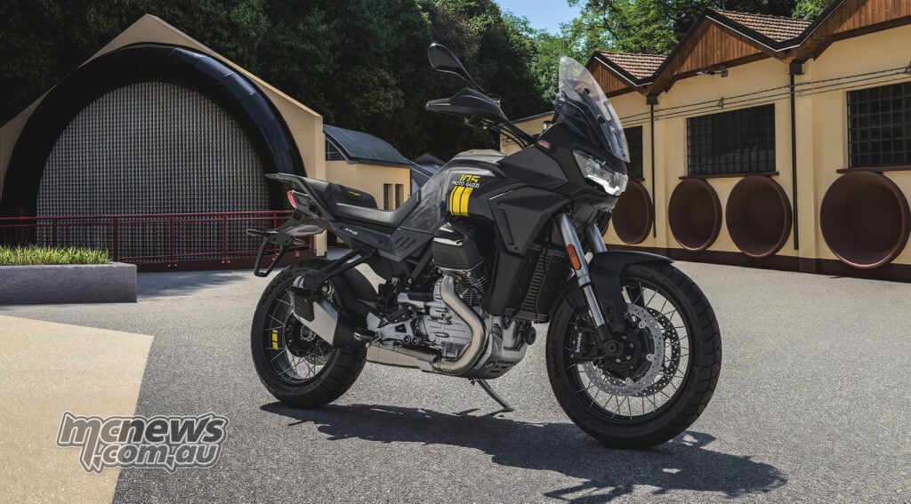 Grey Moto Guzzi Stelvio with yellow 105th-anniversary tank graphics parked outside the historic wind tunnel.