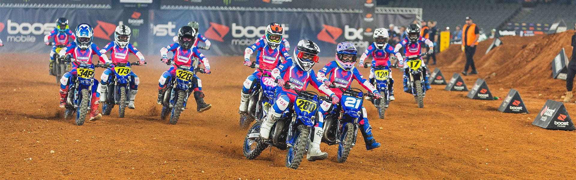 Wide view of Yamaha YZ65 Cup riders racing together on a Supercross track