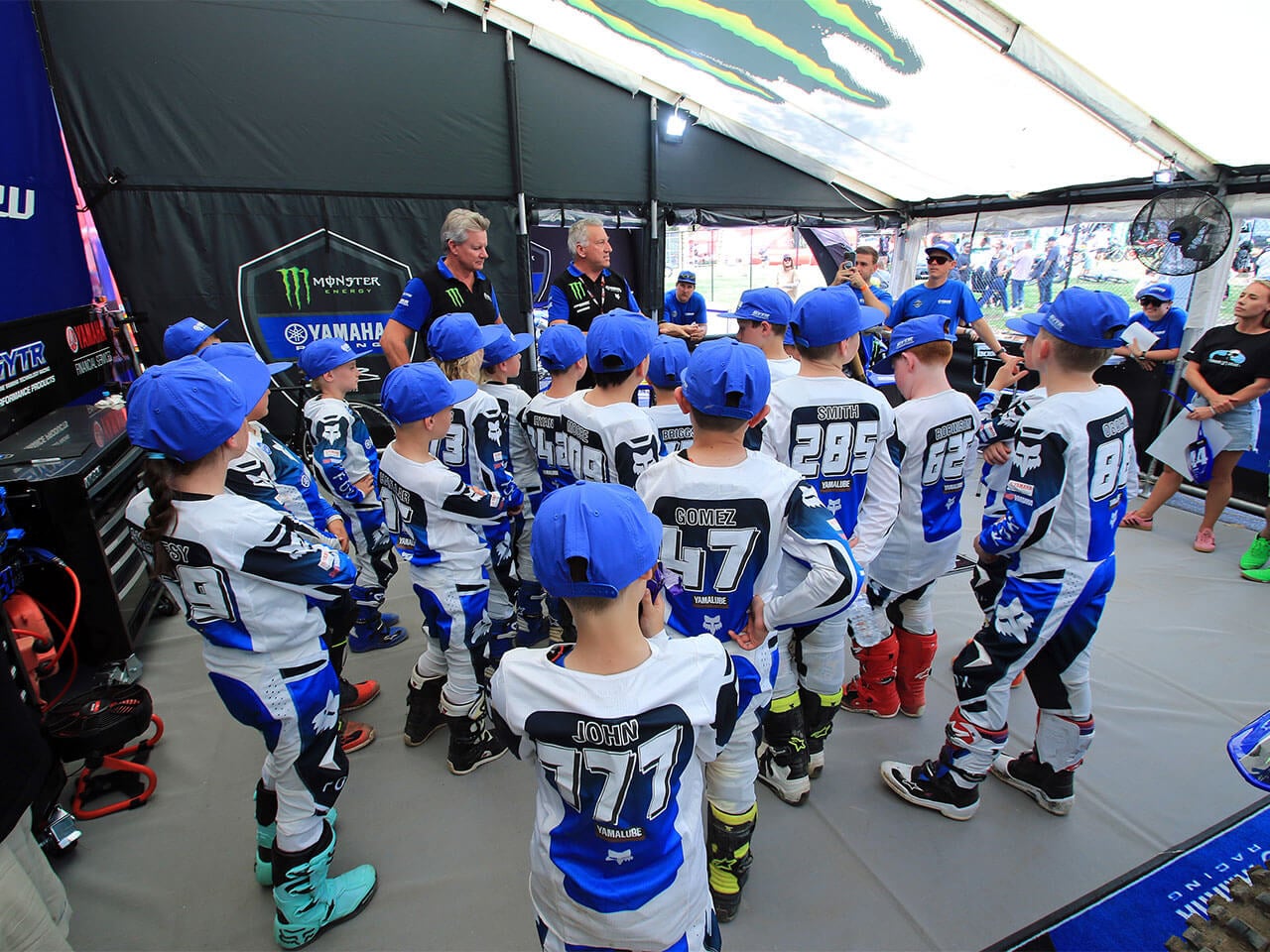 Young Yamaha YZ65 Cup riders gathered for a team briefing in the Yamaha race paddock