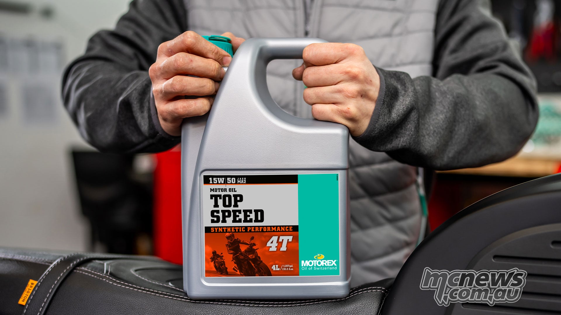 Person holding a four-litre bottle of MOTOREX Top Speed 4T 15W/50 on a motorcycle seat.