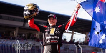 Archie McDonald raises an Australian flag and his gold helmet while wearing the Bagger World Cup champion’s bib at the Red Bull Ring.