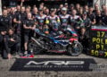 BMW Motorrad World Endurance Team gathers around the #37 M 1000 RR and victory pit board outside its Paul Ricard garage.