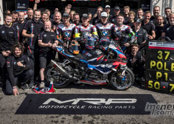 BMW Motorrad World Endurance Team gathers around the #37 M 1000 RR and victory pit board outside its Paul Ricard garage.
