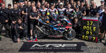BMW Motorrad World Endurance Team gathers around the #37 M 1000 RR and victory pit board outside its Paul Ricard garage.