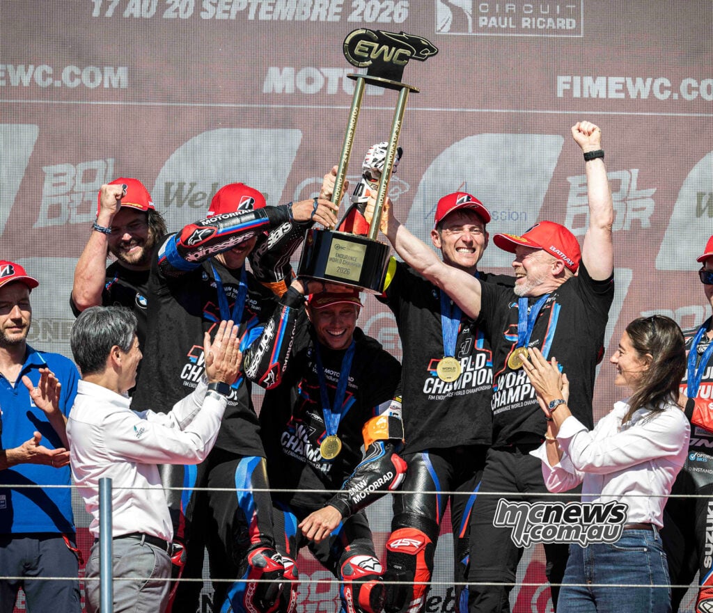 BMW riders and team personnel lift the 2026 FIM EWC championship trophy on the Bol d’Or podium.