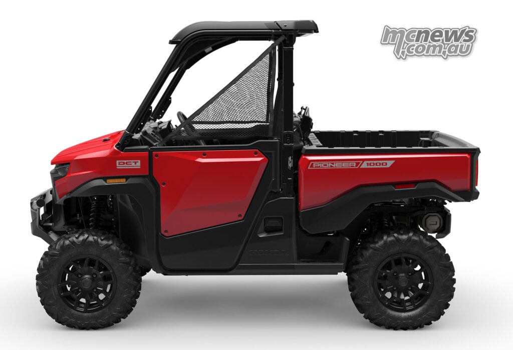 Side profile of red three-seat Honda Pioneer SXS1000-3 Deluxe with cargo bed