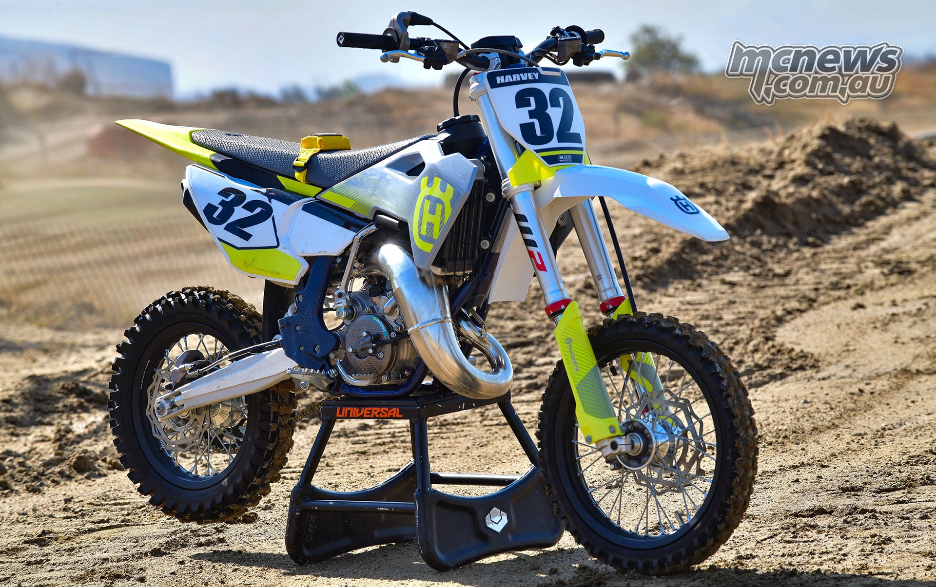 The number 32 2026 Husqvarna TC 65 test bike on a stand beside the motocross track.