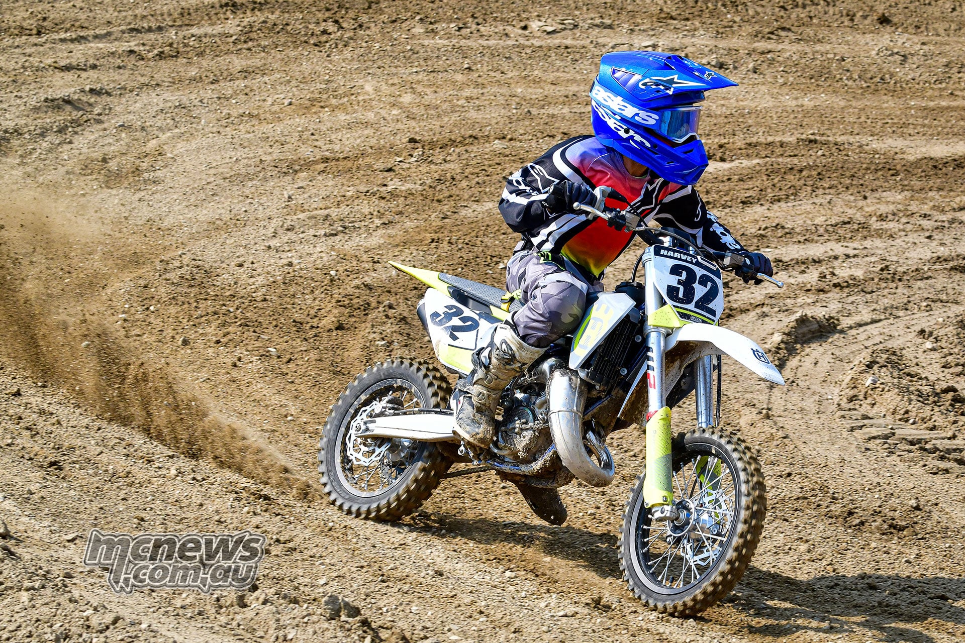 Harvey powers the number 32 2026 Husqvarna TC 65 through a dirt corner, throwing a trail of roost.