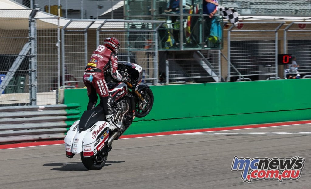 Hayden Gillim lifts the front wheel of his Indian bagger as he crosses the finish line at COTA.