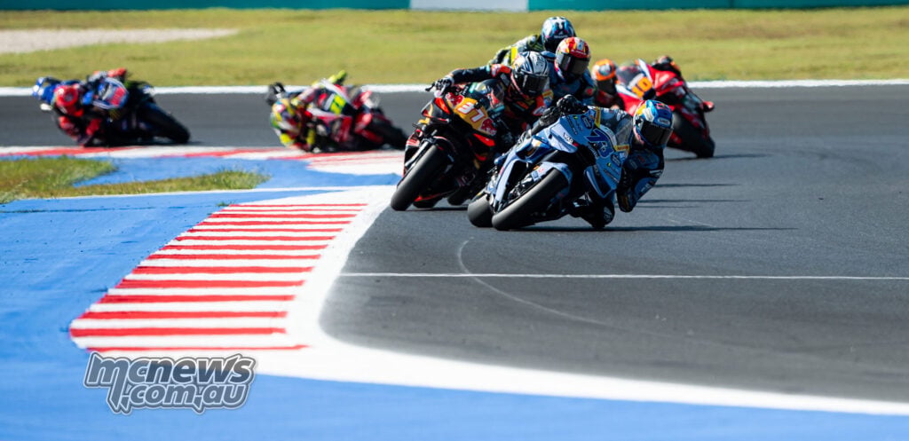 Alex Marquez leads Pedro Acosta and a group of riders beside Misano's red-and-white kerbing.