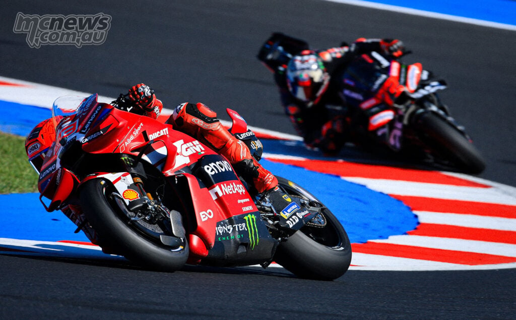Marc Marquez leans his Ducati through a Misano corner with Marco Bezzecchi following on the Aprilia.