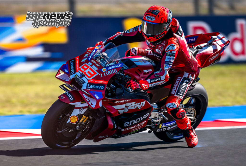 Marc Marquez brakes his number 93 Ducati into a Misano corner with his left leg extended.