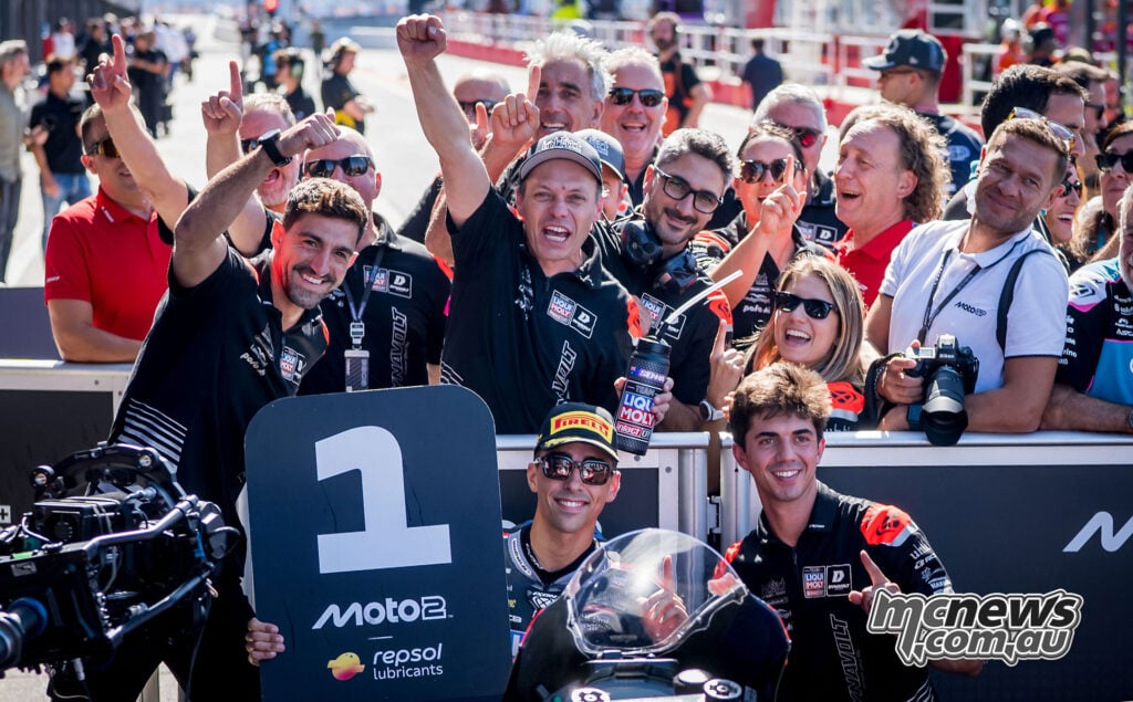 Senna Agius celebrates beside the number one board as his Intact GP team cheers behind him in parc ferme.
