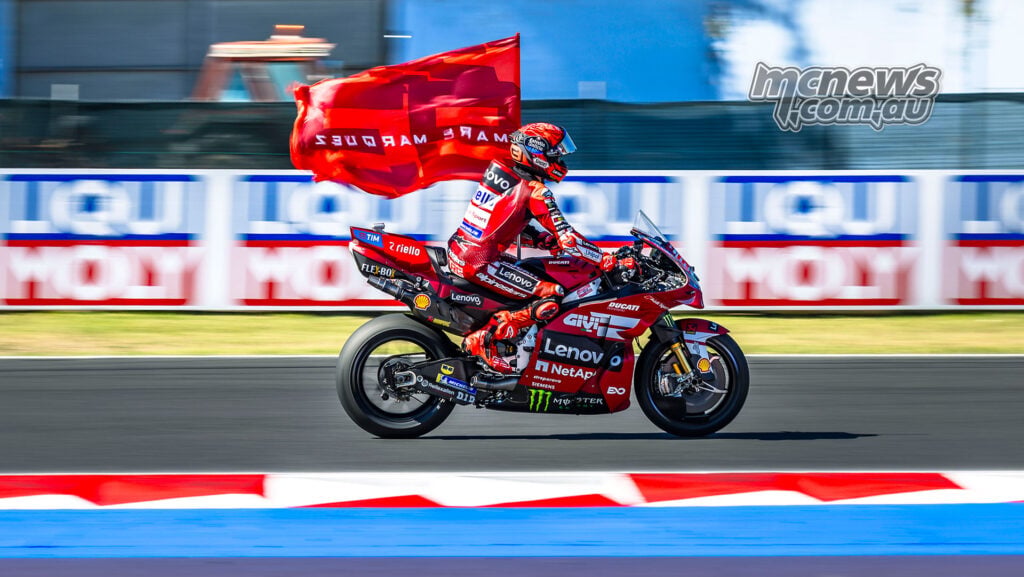 Marc Marquez rides his Ducati around Misano carrying a red flag after his Grand Prix victory.