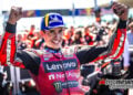 Marc Marquez smiles and raises both arms in parc ferme after winning the Misano MotoGP race.